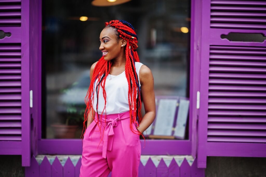 Fille afro-américaine à la mode avec des dreads rouges